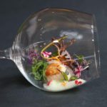 Vieira con algas, cebolla roja, lima, brotes y espuma de mar.