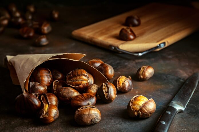Roasted,Grilled,Chestnuts,In,Paper,Bag,On,Black,Grunge,Background.